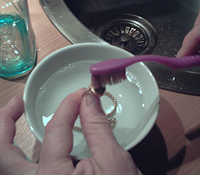 Nettoyage d'une bague plaqué or avec une brosse à dents
